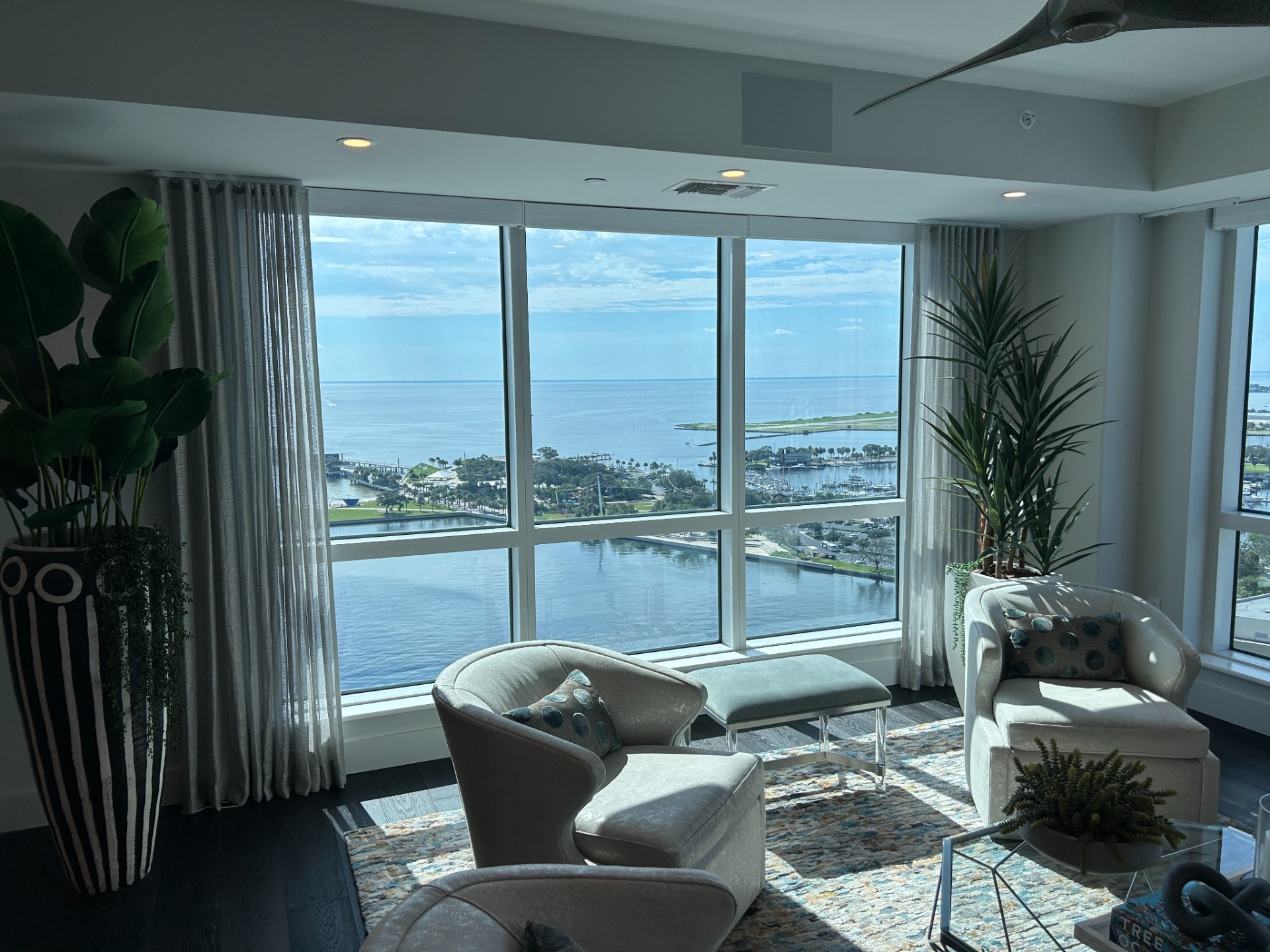 Floor to ceiling sheer drapery in a sunlit modern living room